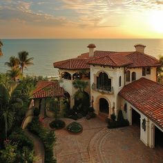 an aerial view of a house with the ocean in the background