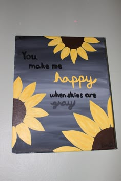 a painted sign with sunflowers and the words you make me happy when skies are gray