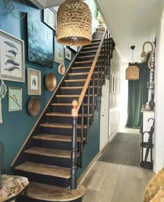 a staircase leading up to a living room with pictures on the wall