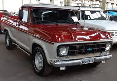 an old red and white pick up truck parked next to each other