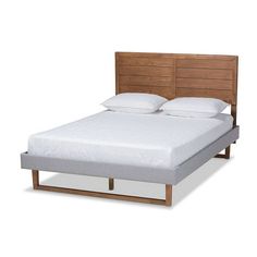 an image of a bed with white sheets and wooden headboard on the bottom side