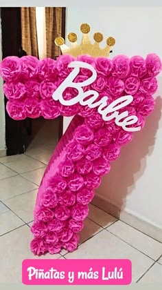 a pink balloon shaped like the letter e with a crown on top that says barbie