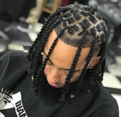 a man with dreadlocks sitting in a barber shop