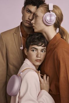 three models with headphones on their ears