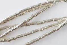 several silver colored beads on a white surface