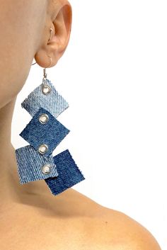 the back of a woman's head wearing earrings with blue fabric and pearls on them