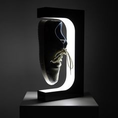 a black and white photo of a pair of shoes in a window frame with light coming through it