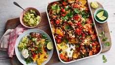 an image of mexican food being served on the table with other dishes and utensils