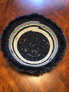 a black and white round rug sitting on top of a wooden table next to a cell phone