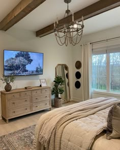 a bedroom with a bed, dresser and television in it's centerpieces