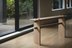 a wooden table sitting in front of a window on top of a hard wood floor