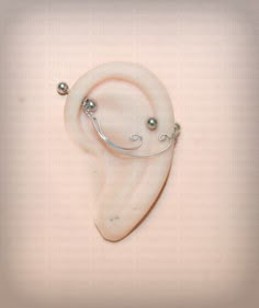 a white ear with two balls attached to it's sides and a wire wrapped around the ear