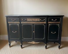 a black and gold painted sideboard in a living room with carpeted flooring