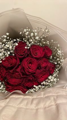 a bouquet of red roses and baby's breath