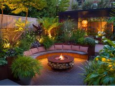 an outdoor fire pit surrounded by plants and trees