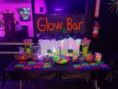 the glow bar is set up with neon lights and candy bars for guests to enjoy