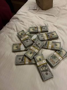 a bunch of money sitting on top of a bed