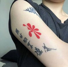 a woman with a tattoo on her arm that has chinese characters and flowers painted on it