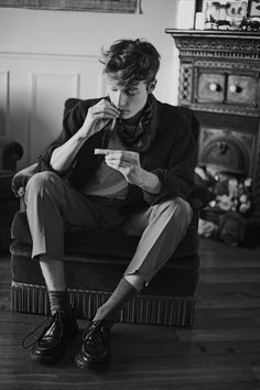 a man sitting on top of a chair holding a cup