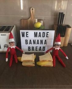 two elfs are sitting next to a sign that says, we made banana bread