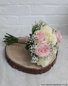 a bouquet of flowers sitting on top of a wooden slice