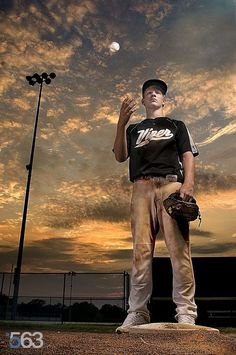 a man standing on top of a baseball field holding a glove and ball in his hand