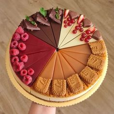 there is a cake that has many different toppings on it, including raspberries and chocolate