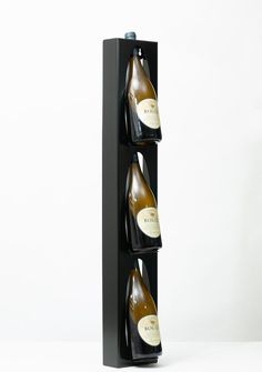 three bottles of wine are in a black display case on a white background with the bottom half open