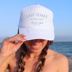 a woman wearing a white hat with the words, last toast on the coast printed on it