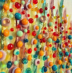 colorful beads are hanging on the side of a wall