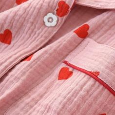 Experience the charm and elegance of our Heart Print Button Up Crepe Pajama set, designed for those who appreciate whimsical touches in their loungewear. This set features a button-up shirt and matching pants, both made with lightweight crepe fabric for a comfortable feel. Adorned with a playful red heart print against a crisp white backdrop, this set is perfect for a cozy night in or a relaxed morning routine. Features: Lightweight Crepe Fabric: Lightweight material that offers a smooth and com Long Sleeve Heart Print Sleep Set, Cotton Bedtime Sets With Pockets, Cotton Loungewear Sets With Button Closure, Heart Print Long Sleeve Pajama Party Sets, Pink Long Sleeve Sleepwear With Heart Print, Cute Cotton Sets With Pockets, Cotton Heart Print Sets For Spring, Cute Heart Print Sleepwear For Spring, Cute Spring Sleepwear With Heart Print