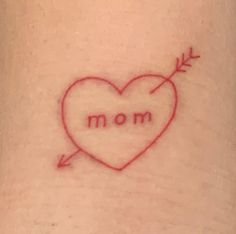 a heart with an arrow on it and the word mom written in cursive writing