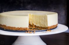 a cheesecake on a cake plate with one slice missing