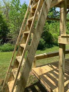 a wooden ladder sitting on top of a lush green field