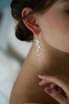 a close up of a person wearing some kind of earring with pearls on it