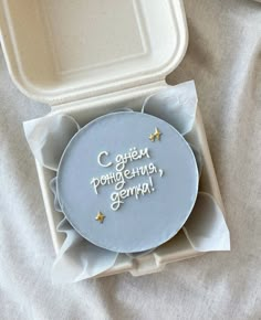 a cake in a box with writing on the side and gold stars around the edges