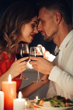 a man and woman sitting at a table with wine glasses