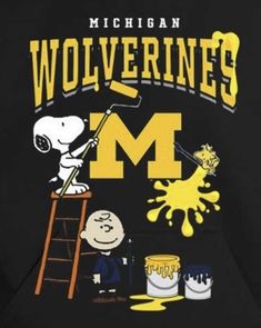 the michigan wolverines logo is painted on a black shirt with yellow paint and other things