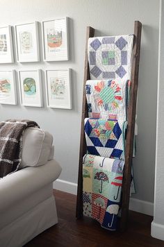 a living room filled with furniture and pictures on the wall next to a white couch