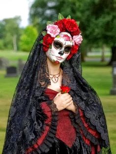 a woman wearing a black and red costume with flowers in her hair