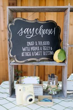 a sign that says say cheese and some lemons on top of a table with other items