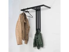 two coats hanging on the wall next to a coat rack and jacket hanger,