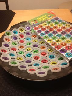 there is a plate that has many different colored candies in it on the table