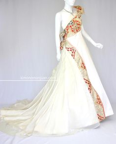 a mannequin dressed in a white gown with red and gold details on it