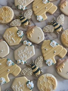 some decorated cookies are laying on a marble counter top with the words love you to the bee and honeycombs