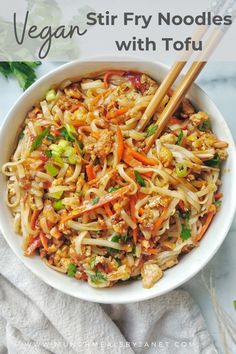 vegan stir fry noodles with tofu in a white bowl on top of a towel