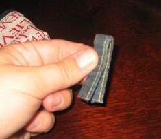 a person holding something in their hand on top of a wooden table