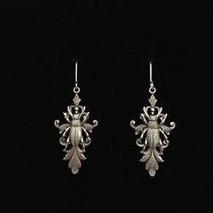 pair of silver earrings on black background