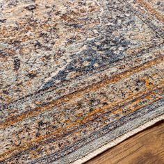 an area rug with wooden flooring and blue, yellow and orange colors on it