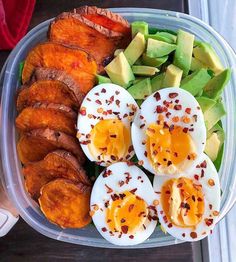 a plastic container filled with hard boiled eggs, avocado and sliced peaches